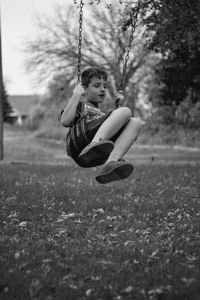 Playful boy on swing at park