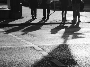 Low section of people standing on sidewalk in city