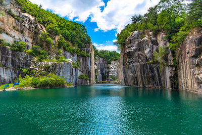 Scenic view of rocks in water against cloudy sky