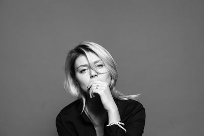 Portrait of young woman against gray background