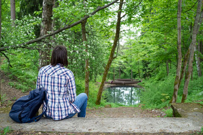 Rear view of senior man sitting in the forest