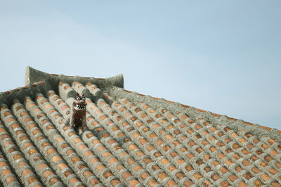 Low angle view of old building roof against clear sky