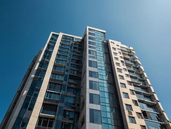 Low angle view of modern buildings against clear blue sky