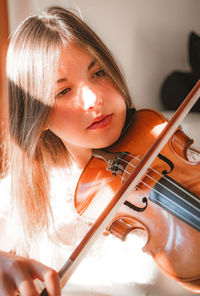 Woman looking away while playing violin