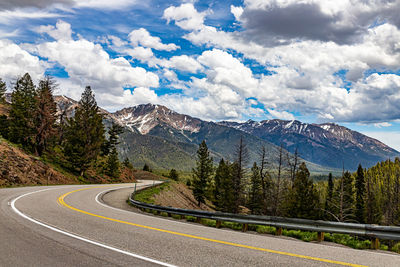 Road by mountains against sky