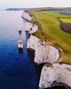 Aerial view of cliff by sea against sky