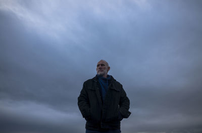 Adult man in winter clothes on beach during sunset. almeria, spain