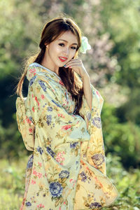 Portrait of smiling young woman standing outdoors