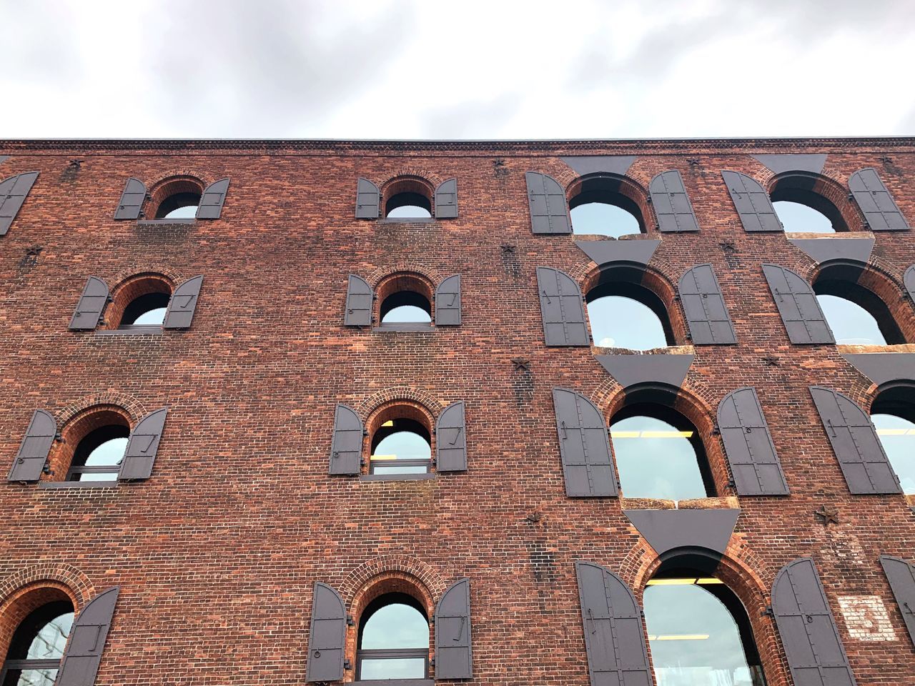 architecture, sky, low angle view, building exterior, built structure, arch, window, day, no people, nature, history, the past, cloud - sky, side by side, in a row, building, outdoors, brick, old, repetition