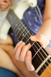 Midsection of man playing guitar