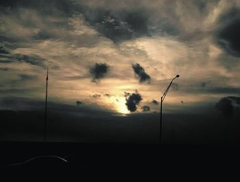 Silhouette of trees against cloudy sky