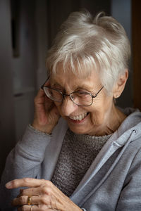 Side view of old lady sitting at home