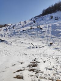 Snow covered land against clear sky