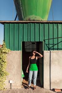 Full length of woman standing against built structure