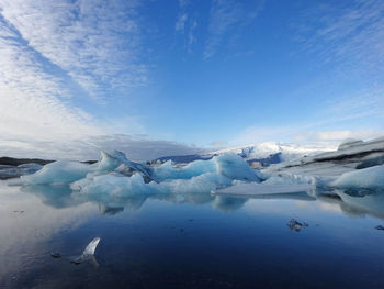 Scenic view of snow covered landscape against blue sky