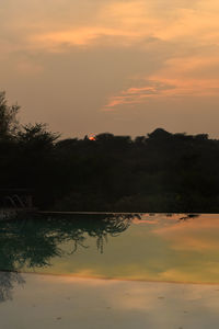 Scenic view of lake against orange sky