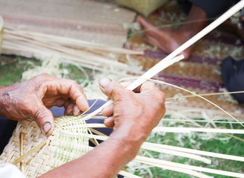 Close-up of hands working in basket