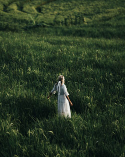 Rear view of woman walking on field