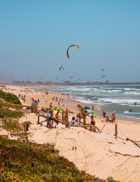 People at beach against sky