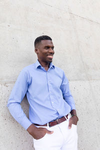 Portrait of handsome smiling with teeth african american man wearing white jeans and blue shirt