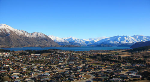 Aerial view of snowcapped mountains against clear blue sky around wanaka new zealand.