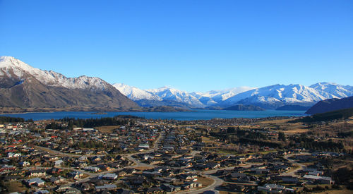 Aerial view of snowcapped mountains against clear blue sky