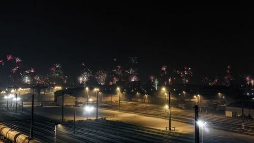 Illuminated city against sky at night