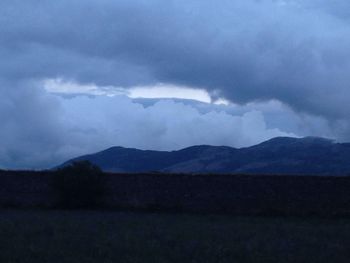 Scenic view of mountains against cloudy sky