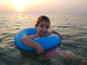 Portrait of smiling young woman at beach during sunset