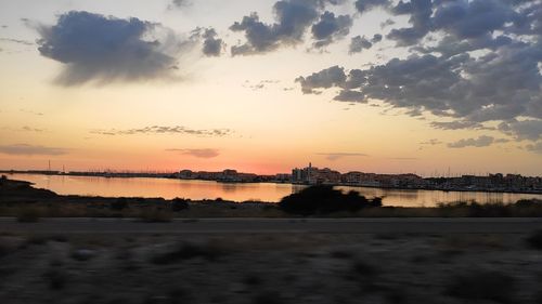 Scenic view of silhouette city against sky during sunset