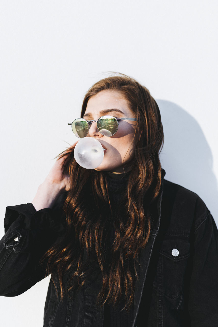 young adult, studio shot, white background, young women, person, lifestyles, front view, indoors, portrait, headshot, long hair, looking at camera, leisure activity, waist up, holding, casual clothing, head and shoulders