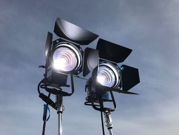 Low angle view of illuminated lighting equipment against sky
