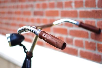 Close-up of bicycle against brick wall