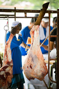 The process of cutting the meat during hari raya. meats hanging on the hook.