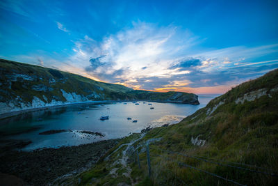 Scenic view of boats in sea against sky during sunset