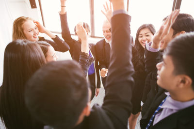 High angle view of business people with arms raised