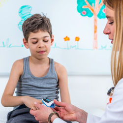 Female doctor examining boy at clinic