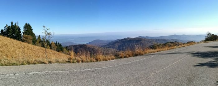 Panoramic view of road and mountains against clear sky