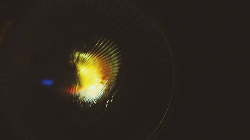 Close-up of illuminated lighting equipment against black background