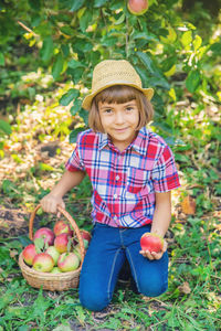 Portrait of cute boy holding fruits at farm