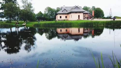 Reflection of building on lake against sky