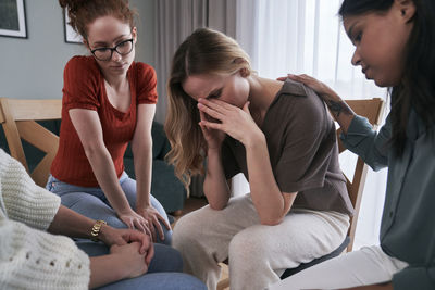 Friends consoling woman at support center