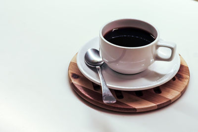 Coffee cup on table against white background