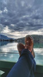 Low section of man in lake against sky