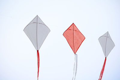 Low angle view of kites hanging against clear sky