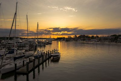 Sailboats in sea at sunset