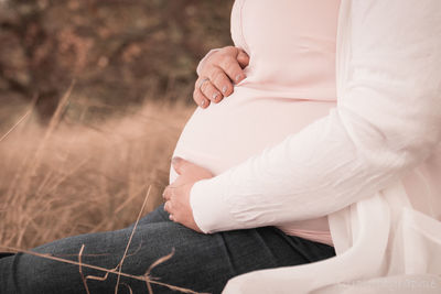 Midsection of woman sitting outdoors