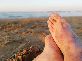 Low section of person relaxing on beach