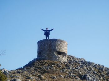 Low angle view of man on mountain against sky