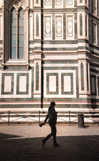 Full length of man walking against building in city